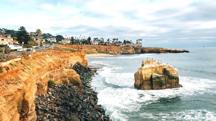 Cliffs with the ocean below them under a blue sky with clouds