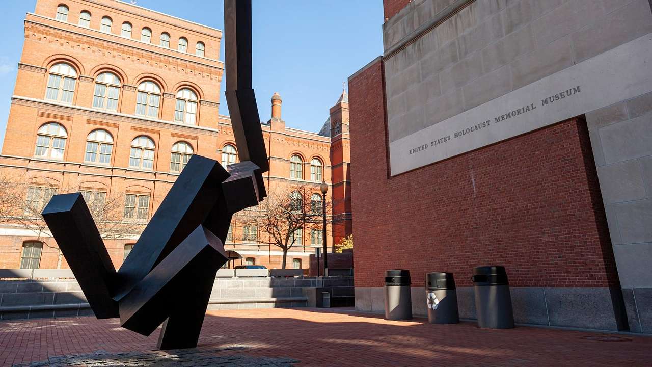 A sculpture in front of a wall that says "United States Holocaust Memorial Museum"