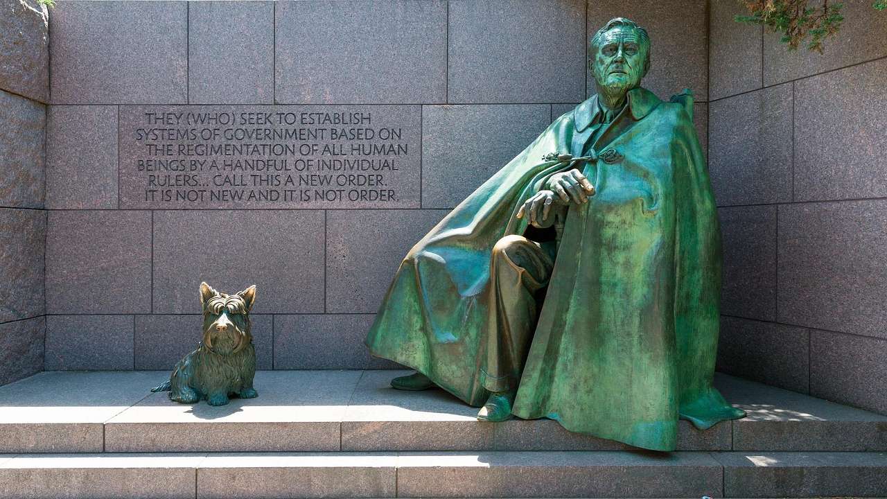 A green statue of Franklin D. Roosevelt with his terrier dog
