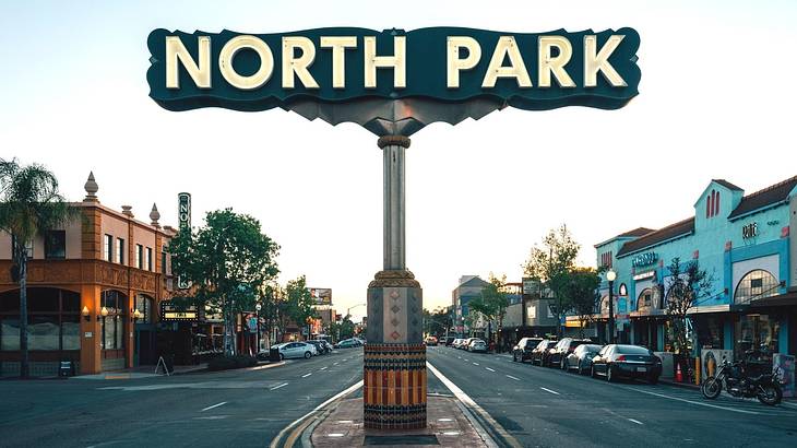 A sign that says North Park on a street with buildings behind it