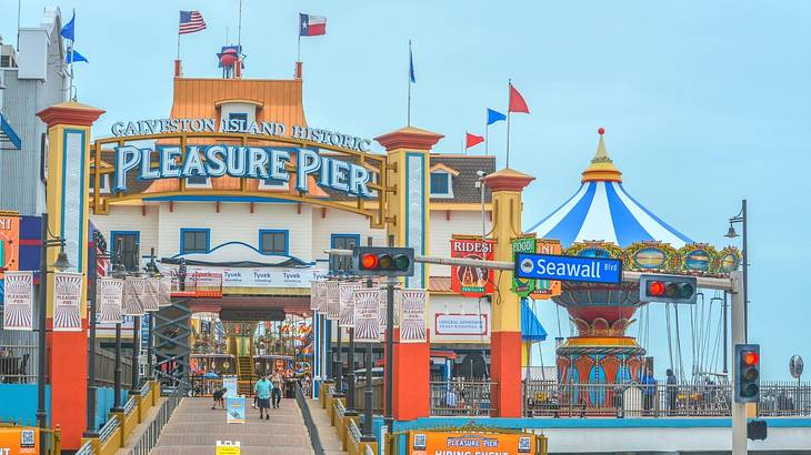 A colorful amusement pier with a "Pleasure Pier" sign