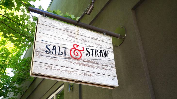 Looking up at a white signboard on a wall saying "Salt & Straw"