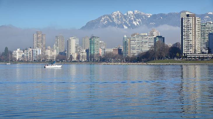 View of a city landscape along water with mountains in background
