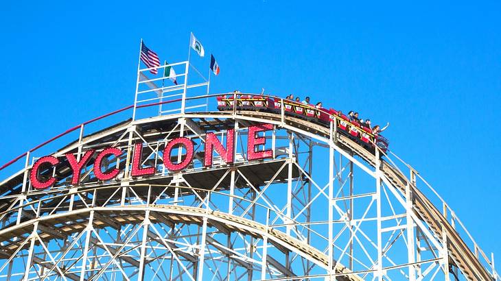 A roller coaster with a sign that says "Cyclone" on a clear day