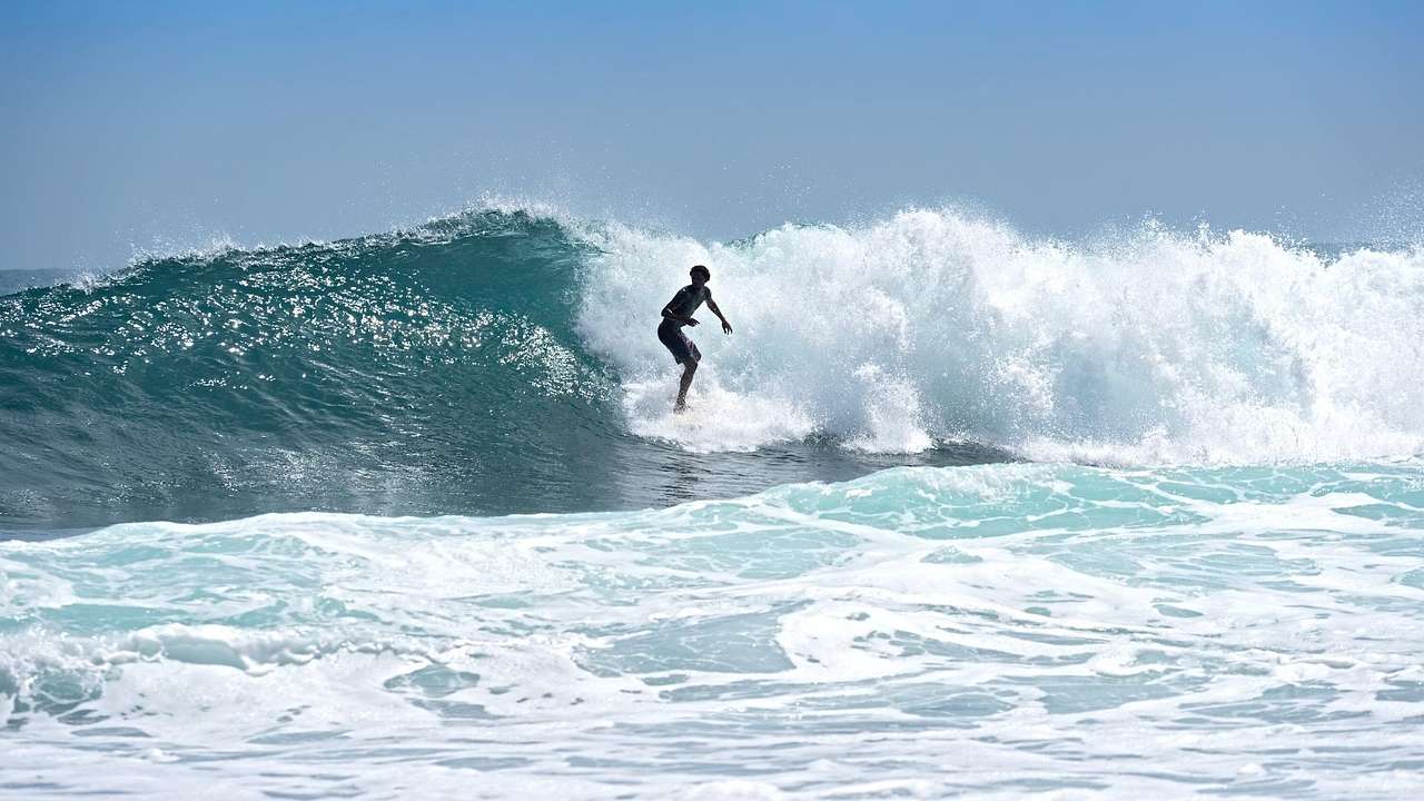 A person surfing amongst large waves