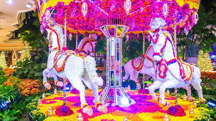 A pink, white, yellow, and orange carousel display made from flowers