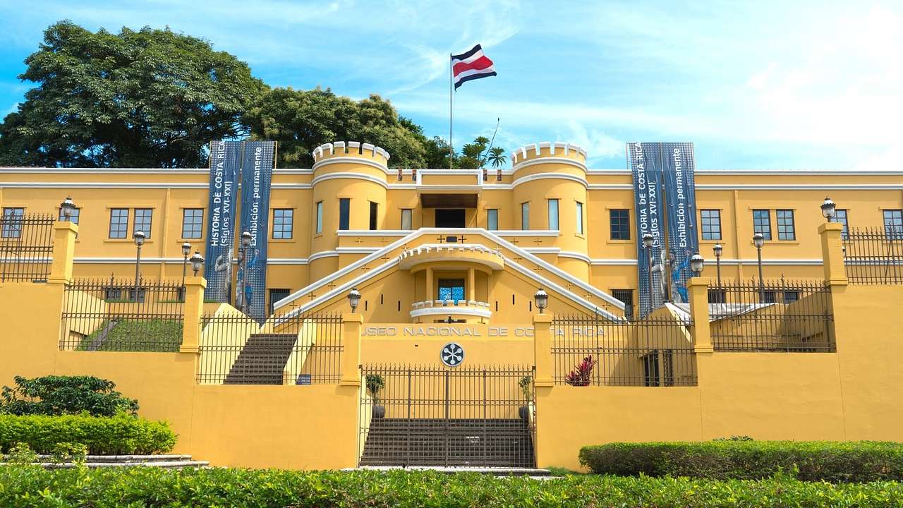 A yellow castle-like building with a flag and banners on it