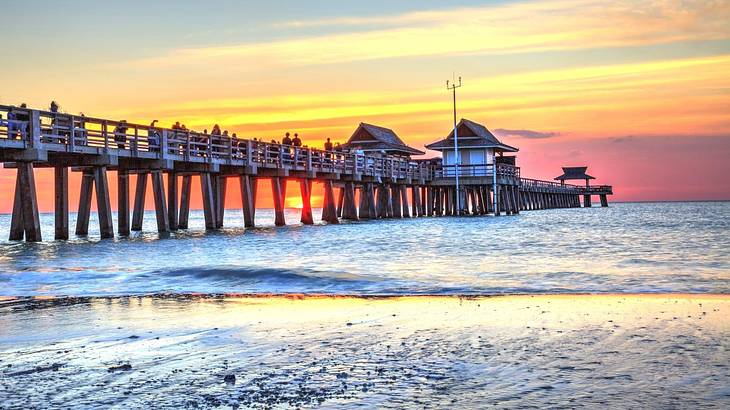 A wooden pier over the ocean at sunset