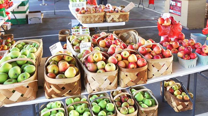 A market with stalls that have apples in baskets