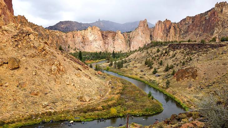 A narrow river winding through rugged cliffs under an overcast sky