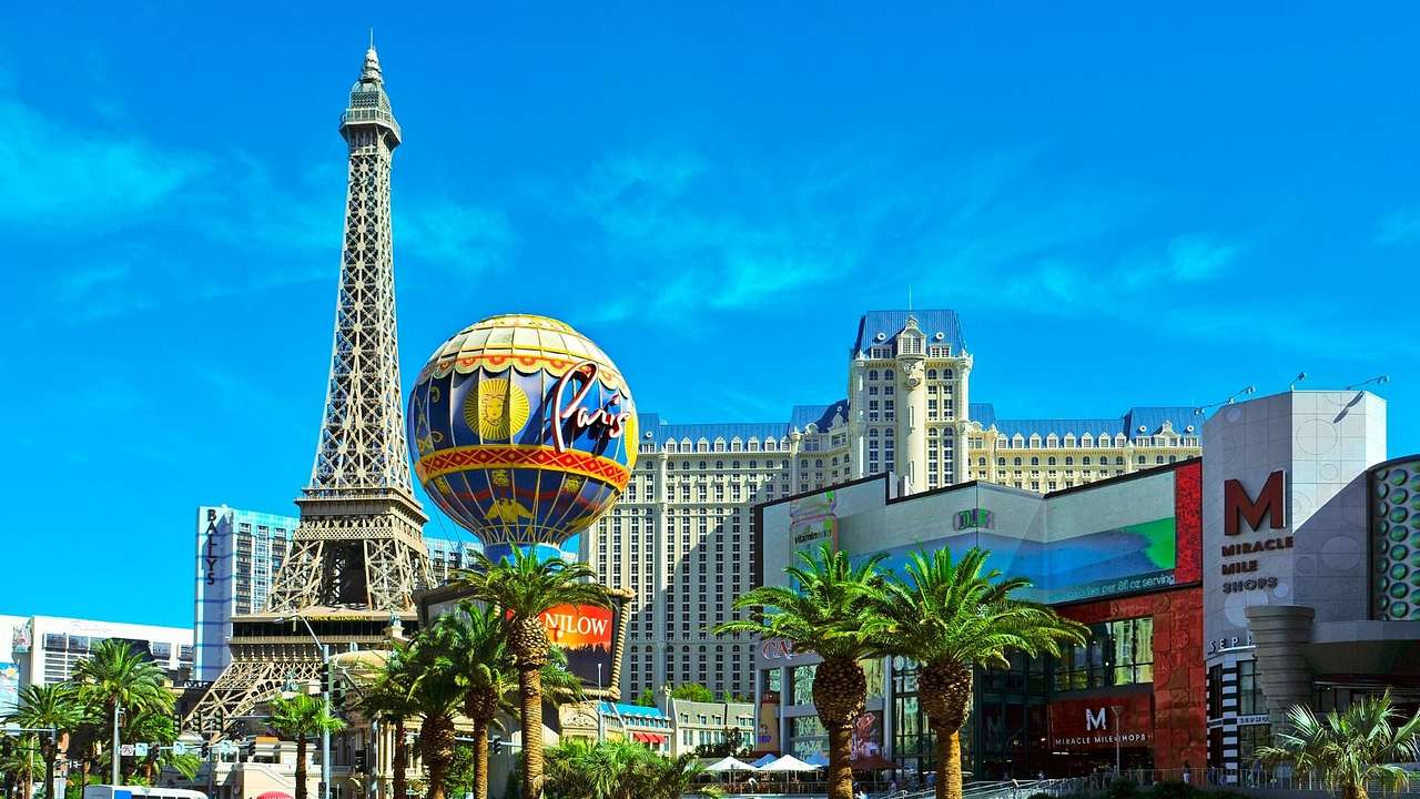 A replica of the Eiffel Tower and a hot air balloon model with palm trees in front