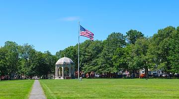 A green with a bandstand and US flag on it and a path down the middle