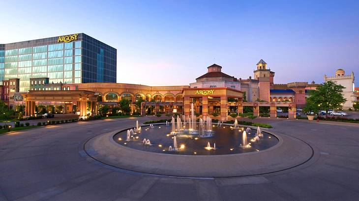 A hotel and casino complex with a mirrored building and a fountain in front of it