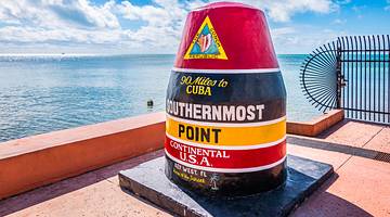 A red-black-yellow buoy with the text "Southernmost Point of The Continental USA"