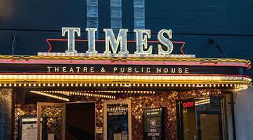 An entrance to a bar with illuminated signs that say "Times Theatre & Public House"