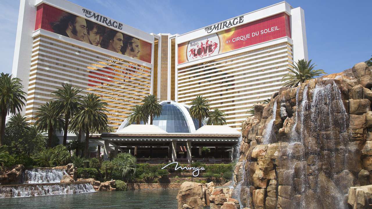 A hotel with a Mirage sign on it and a dome building and water feature in front of it