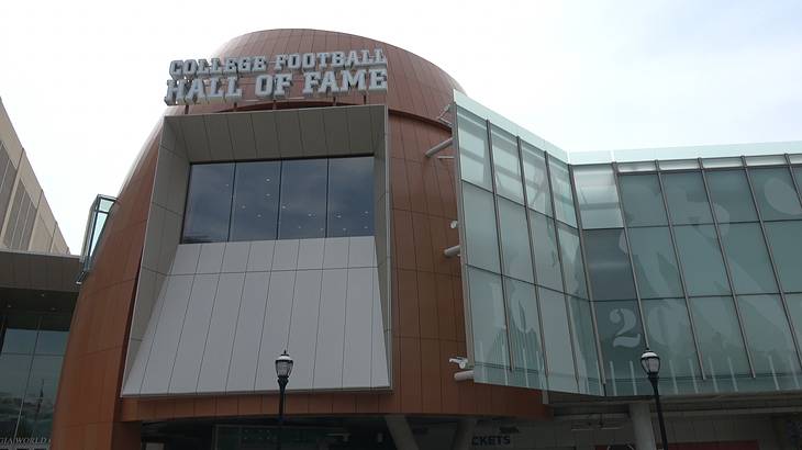 Looking up at a glass modern building, with a "College Football Hall of Fame" sign