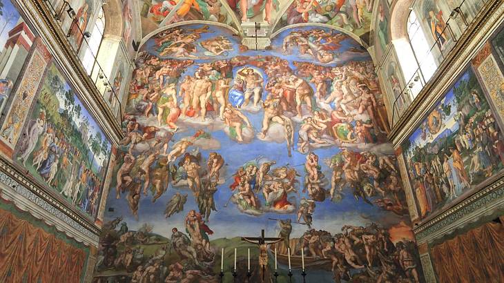 The wall and ceiling of the Sistine Chapel painted with colorful religious images