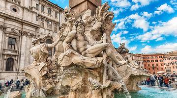 A water fountain with Roman statues and a square behind it
