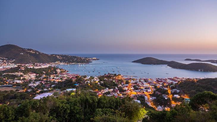 A view across a town, mountains, and a bay at sunset