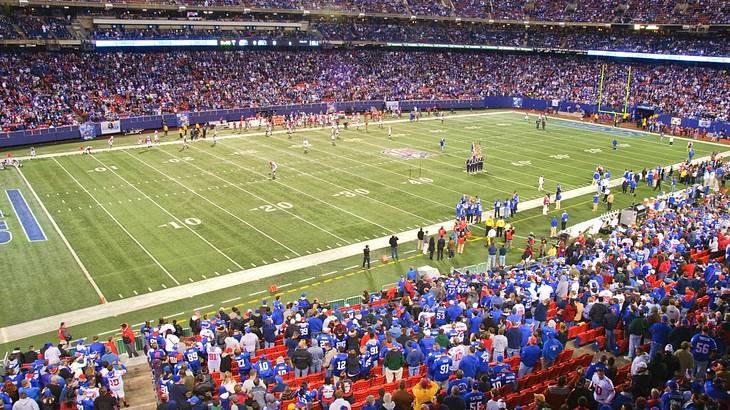 A football stadium with fans in the stands in blue jerseys