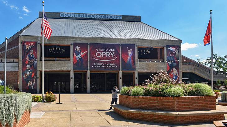 A music hall with a Grand Ole Opry banner and flags and a path in front of it