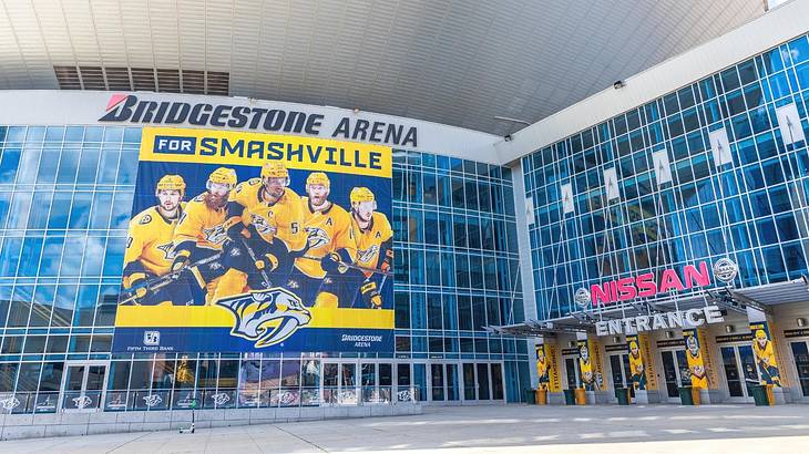 A glass arena with a "Bridgestone Arena" sign and a yellow banner with hockey players