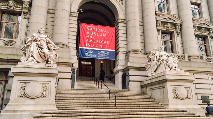 A museum with a "National Museum of the American Indian" banner and statues outside