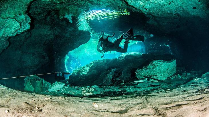 A person scuba diving in an underground cenote