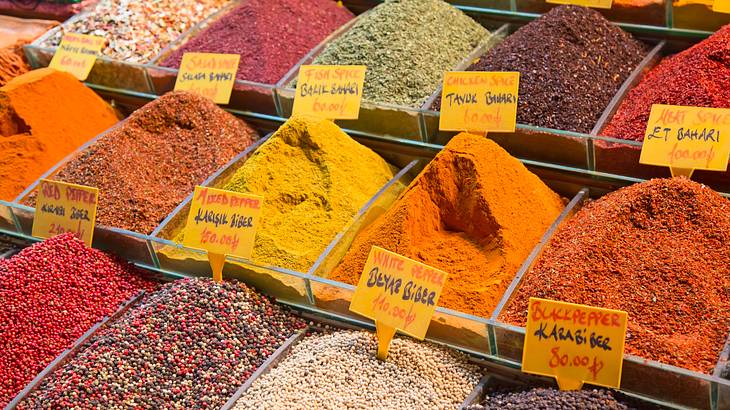 Various spices of different colors on display on a market stall