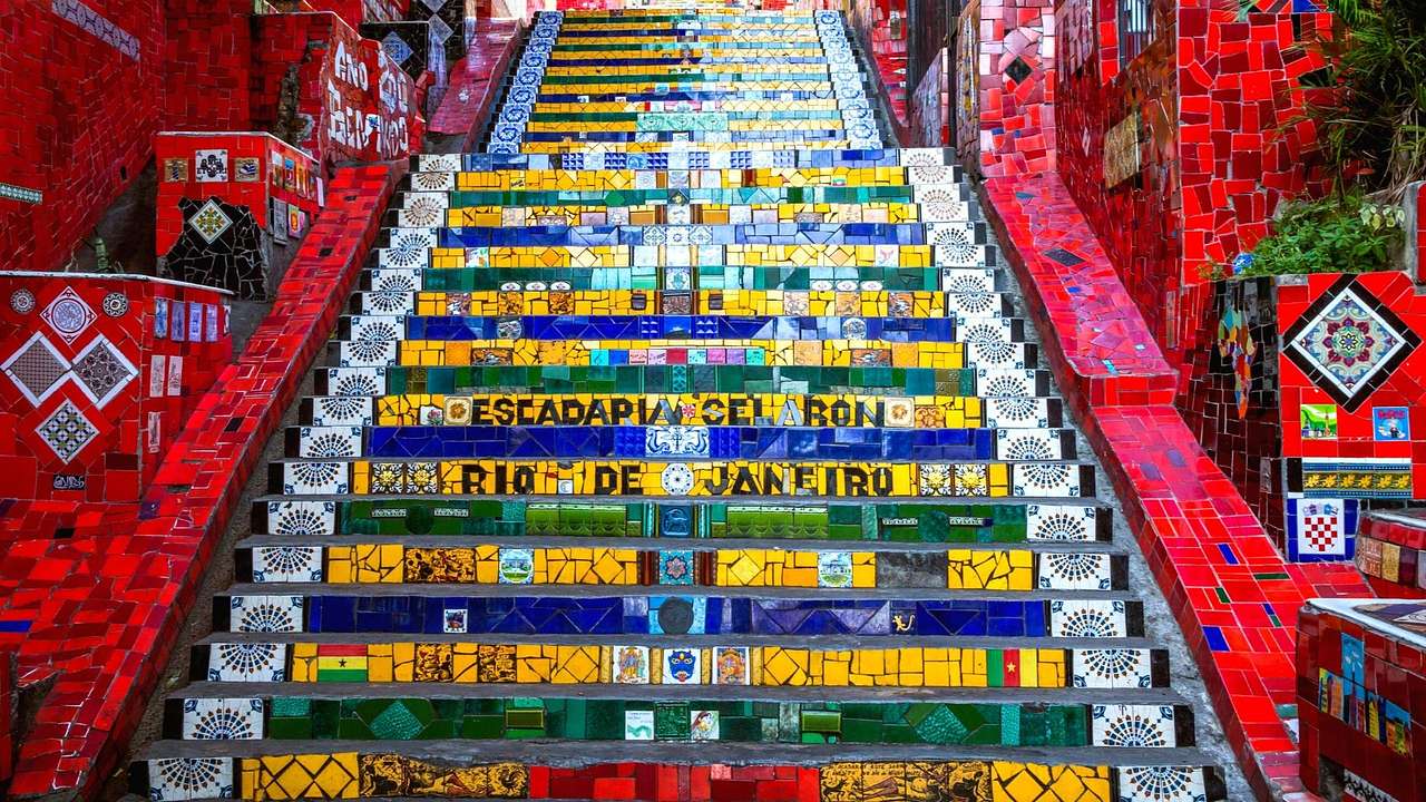 A colorful tiled staircase with the words "Rio De Janeiro" and "Escadaria Selaron"