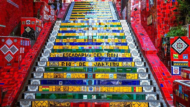 A colorful tiled staircase with the words "Rio De Janeiro" and "Escadaria Selaron"