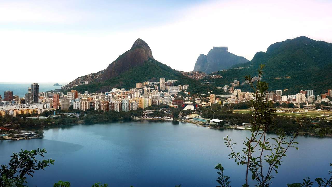 A body of water surrounded by buildings and greenery-covered hills