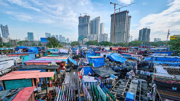 Clothes hanging in an open-air laundry with city buildings at the back