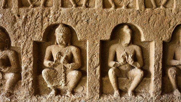 Buddhist statues carved into an ancient wall