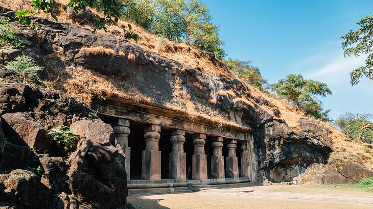 A hill with a structure with columns carved into it