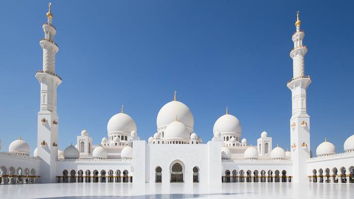 A majestic white mosque with several domes and two towers
