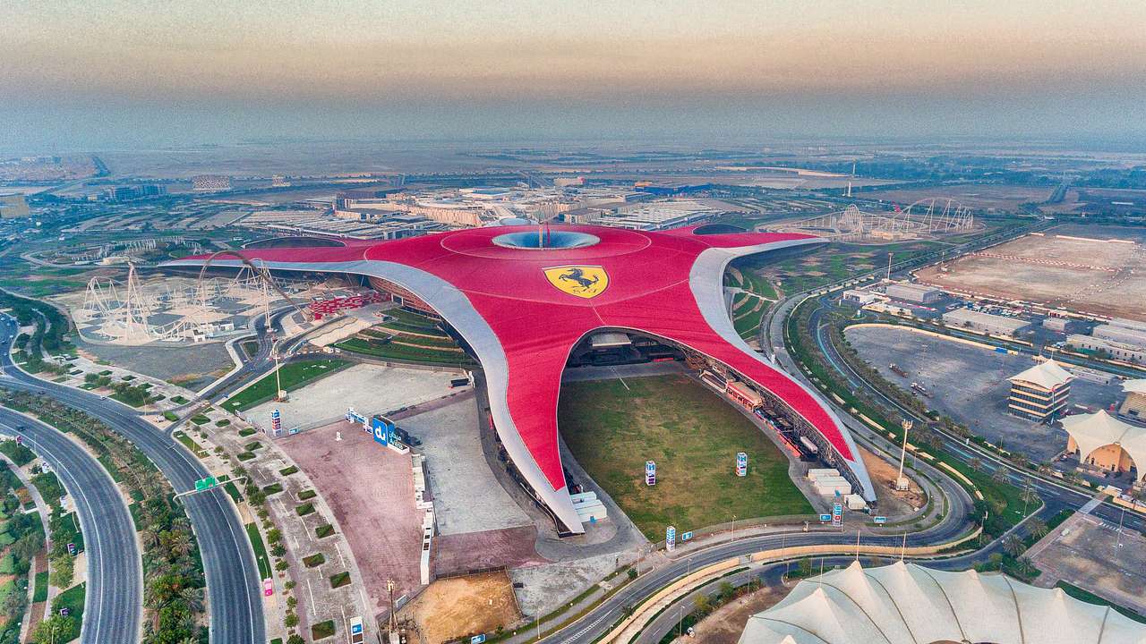 An aerial view of an amusement park with a red roof and a Ferrari logo
