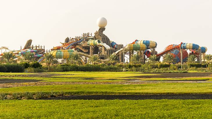 A multi-coloured roller coaster surrounded by green grass