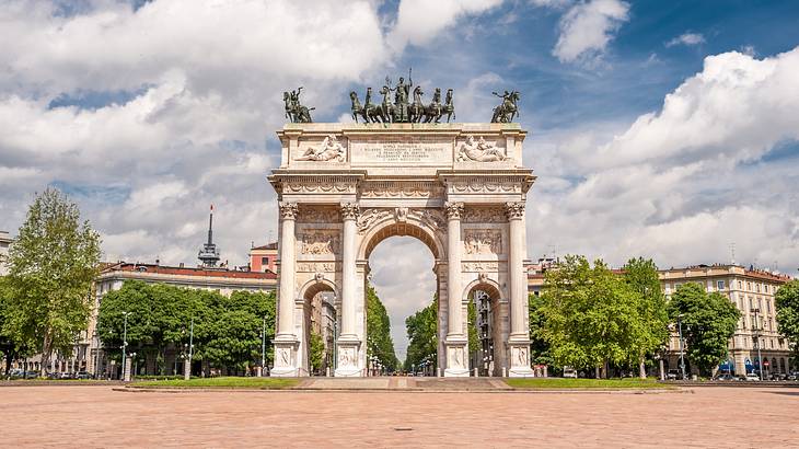 A tall monument with three arched openings and horse statues on top of it