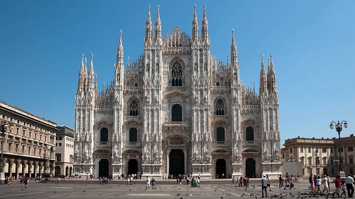 A gray cathedral building with Italian gothic architecture under a clear blue sky