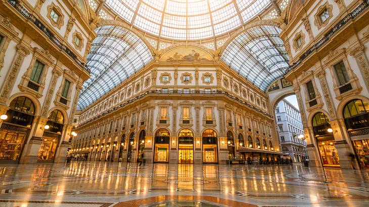 The interior of a gold and white shopping mall with a glass ceiling