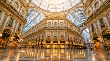 The interior of a gold and white shopping mall with a glass ceiling