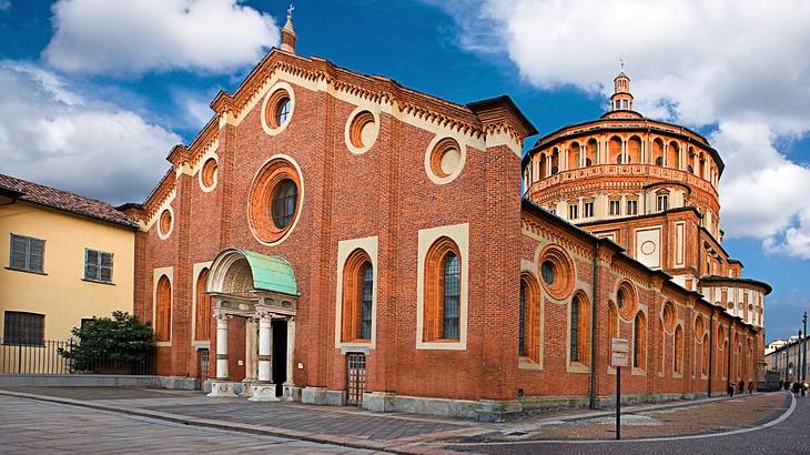 A red brick renaissance building under a partly cloudy sky