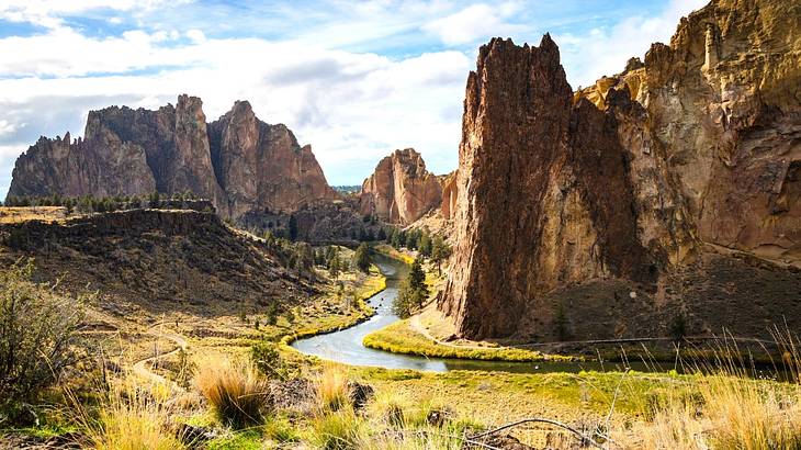 Towering volcanic spires overlooking a river meandering through vegetation and bushes