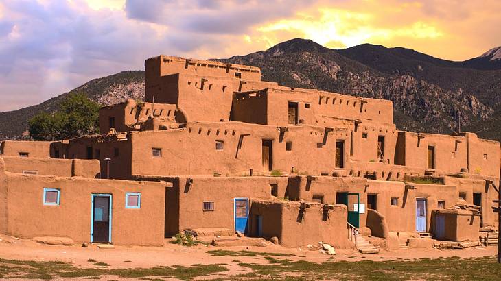 A village with numerous old dwellings against a mountain covered with greenery A village with numerous old dwellings against a mountain covered with greenery