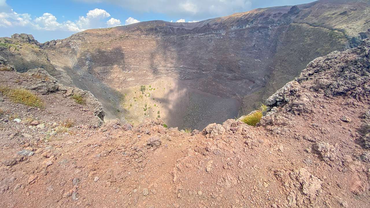 Looking down into a massive round crater hole inside a mountaintop