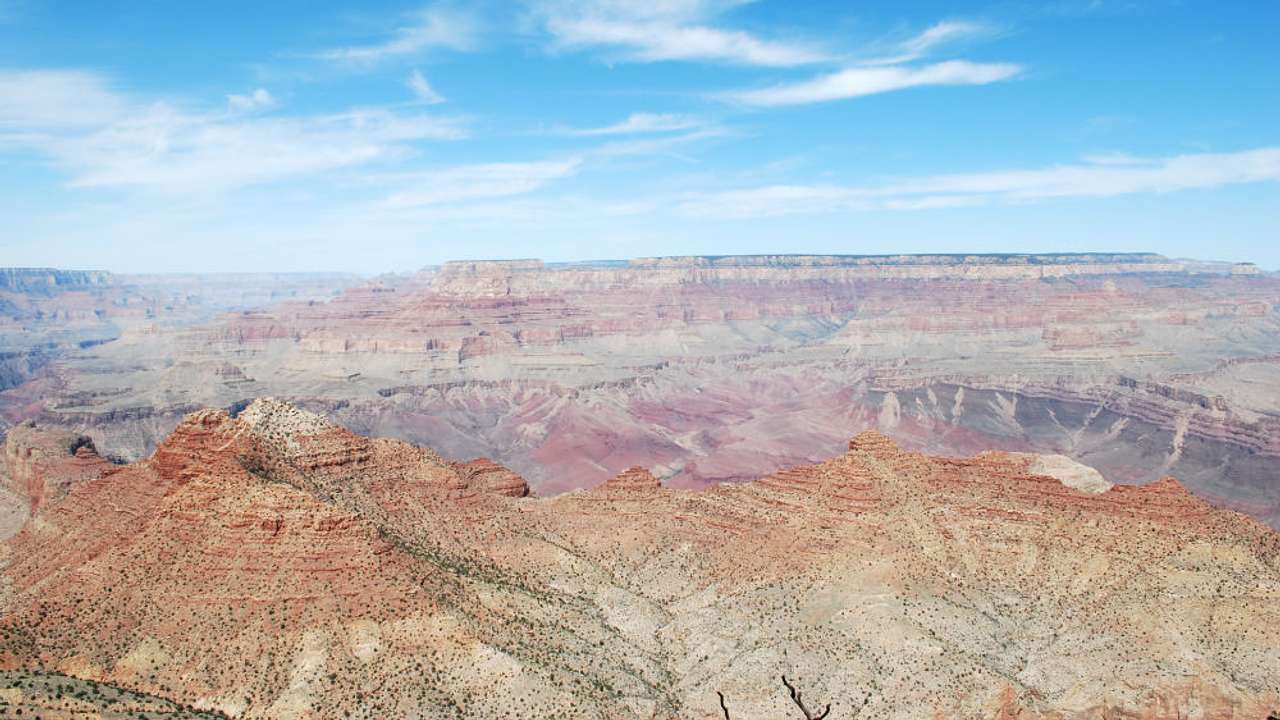 A vast dry canyon landscape against blue sky from above