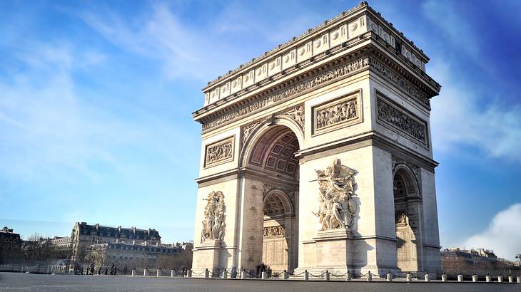 A massive arch with ornate decorations at daytime from below