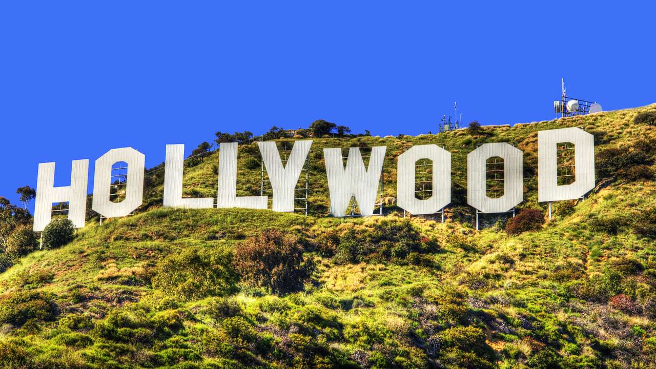 White-letter signs spelling out Hollywood on a green hill, on a clear day